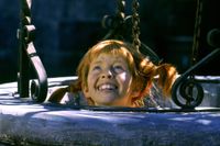 Barnskådespelaren Inger Nilsson i rollen som Pippi Långstrump gömmer sig i en brunn under filminspelningen av 'Pippi på de sju haven' på borggården i Vaxholms fästning strax utanför Stockholm i augusti 1969.