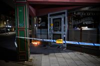 Ljus och blommor vid den avspärrade krogen i centrala Sandviken där två män i 20- respektive 70-årsåldern mördades och ytterligare två personer skadades.