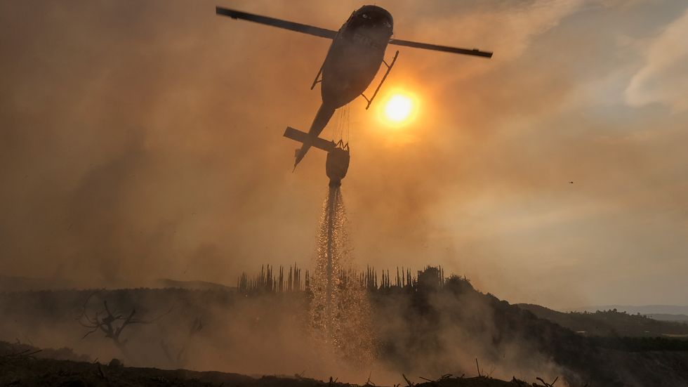 En helikopter dumpar vatten över Fairviewbranden på torsdagen.