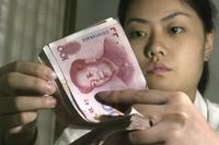 En bankanställd räknar kinesiska yuan.