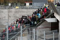 Polis övervakar kön av ankommande flyktingar i snålblåsten vid Hyllie station utanför Malmö i november förra året.