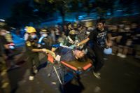 En man som skottskadats i samband med protester i Thailands huvudstad Bangkok förs bort på bår.