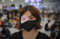 Demonstrant på flygplatsen bär en ögonlapp i protest mot polisens agerande. 