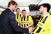 Borussia Dortmunds karismatiske manager Jürgen Klopp skriver autografer vid ankomsten till Stansteds flygplats.