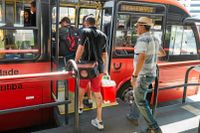 En av de stora bussarna plockar upp passagerare i Curitiba.