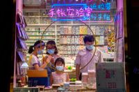 Människor i skyddsmask i en butik i Peking, Kina, där den ökande smittspridningen medför nya restriktioner för medborgarna.