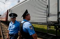 Ukrainsk polis övervakar när tåget med passagerarnas kvarlevor passerar genom staden Charkiv.