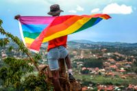 En hbtq-person i Uganda håller upp prideflaggan. I våras införde landet dödsstraff mot homosexualitet.