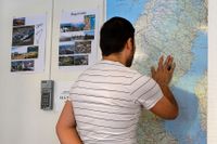 En man tittar på en Sverigekarta på Migrationsverkets anläggning i Märsta.