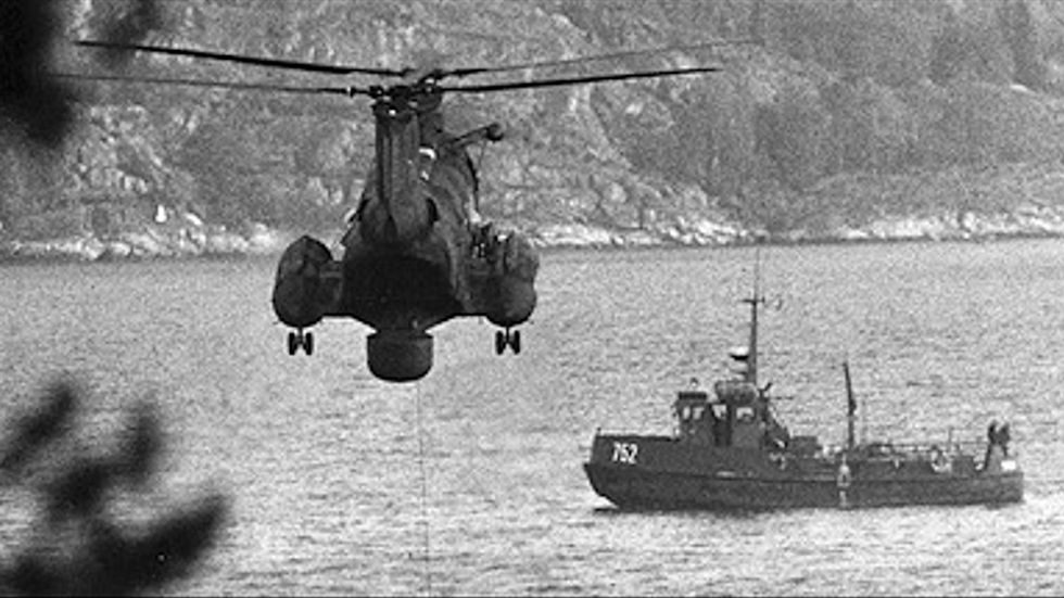 En av marinens helikoptrar med en hydrofon i vattnet spanar efter en eller flera fr ämmande ubå tar som misst änktes operera i Hirsfjärden nära Musköbasen i Stockholms skärgård i oktober 1982. 