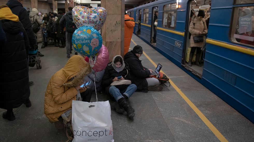 Människor tar skydd i Kievs tunnelbana under måndagens ryska robotattacker.