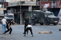 Palestinier i drabbning med israelisk militär i staden Nablus på Västbanken på fredagsmorgonen.