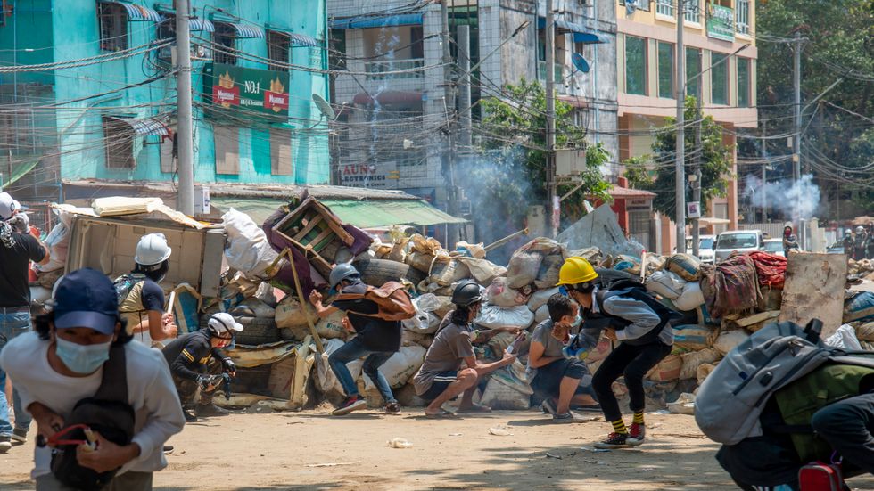 Beväpnade styrkor beskjuter demonstranter med tårgas när de samlats i staden Rangoon i mars. Våldet får nu Sverige att lägga om sitt bistånd. Arkivbild.