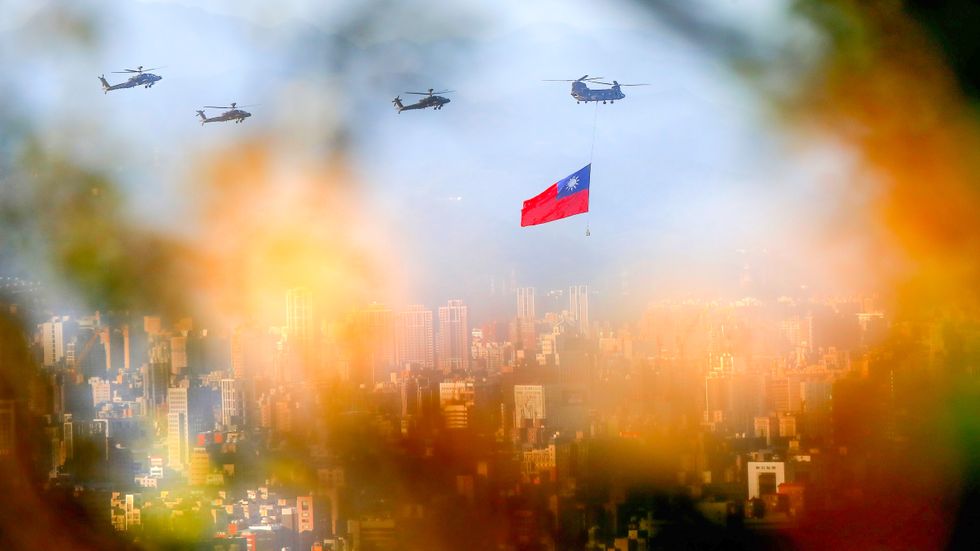 Taiwanesiska helikoptrar flög med Taiwans flagga över huvudstaden Taipei på tisdagen. 