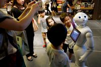 Nyfikna barn ställer frågor till den självlärande roboten Pepper i Japan sommaren 2015.