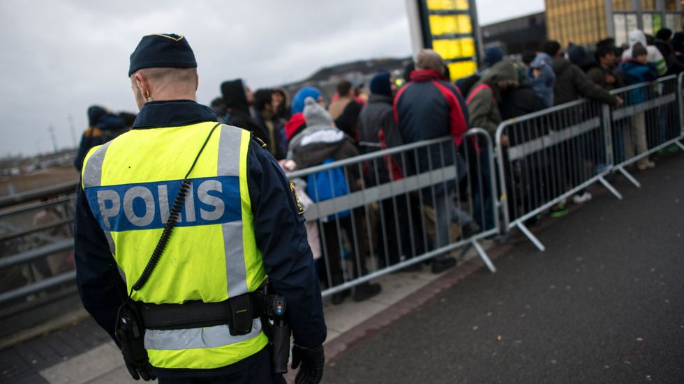 Polis övervakar kön av ankommande flyktingar vid Hyllie station utanför Malmö.