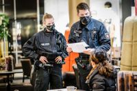 Polis kontrollerar vaccinbevis på en restaurang i Hannover.