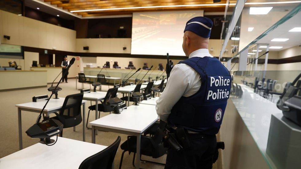 En polis på plats i den ombyggda rättegångssalen i Bryssel där de åtalade för terrordåden 2016 nu ställs inför rätta.
