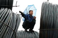En arbetare sitter på vajrar vid en stålmarknad i Taiyuan i Kina.