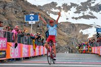 Ilnur Zakarin sträcker upp händerna efter etappsegern i Giro d'Italia, bland de snötäckta alptopparna i Italien.