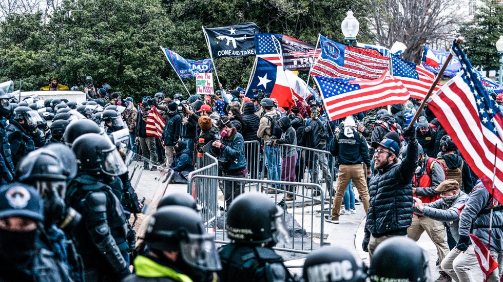 Trumpsupportrar och polis utanför Kapitolium den 6 januari.