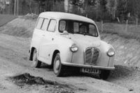 En Austin A30 Countryman kämpar sig fram på riksväg 13 strax söder om Bjästa, nån mil söder om Örnsköldsvik. Det är slutet av maj 1960 och stopp för byggande och underhåll av vägar i Sverige.