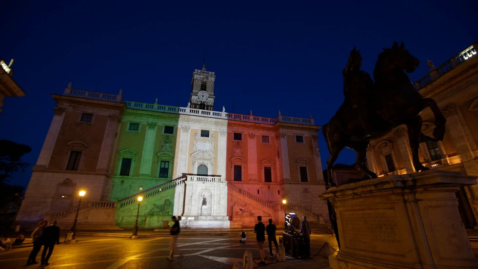 Senatspalatset på Capitolium i Rom, upplyst i den italienska flaggans färger. Arkivbild.