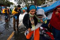 Människor tar skydd från regnet i en idrottsanläggning i Tijuana i Mexiko.