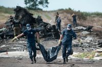 Räddningspersonal röjer bland vrakdelarna efter MH17.