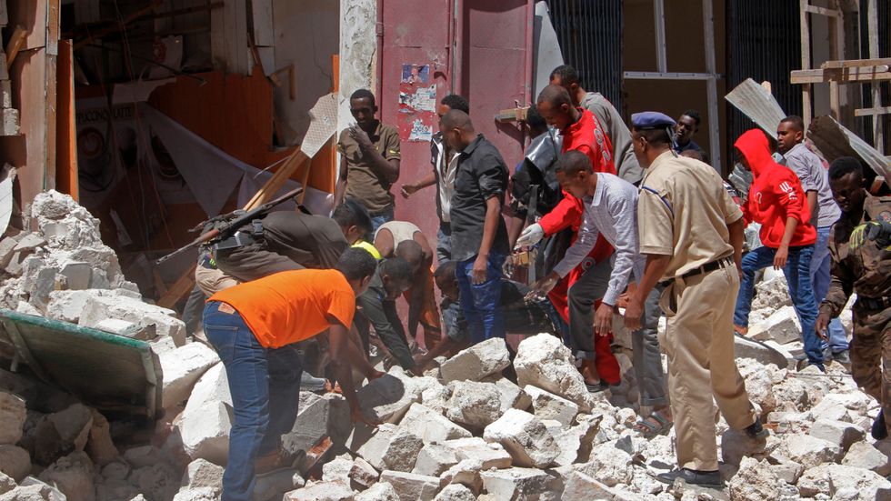 Räddningsarbetare söker efter överlevande i ruinerna efter explosionen i Mogadishu.