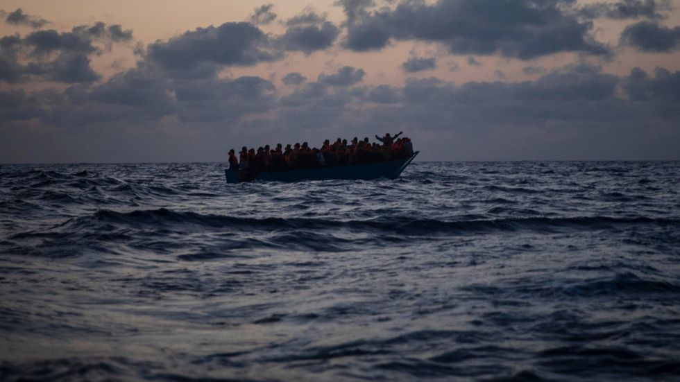 Afrikanska migranter väntar på assistans från spanska volontärarbetare, sedan de försökt korsa Medelhavet från Libyen i en ranglig trädbåt. Bilden togs den 8 september 2020.