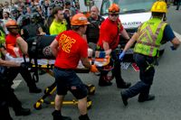 En av de skadade förs undan efter att en bil kört in bland motdemonstranter under den högerextrema manifestationen i Charlottesville i Virginia i USA.