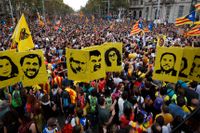 Demonstranter bär porträtt på dömda separatistledare under fredagens massprotest i Barcelona.