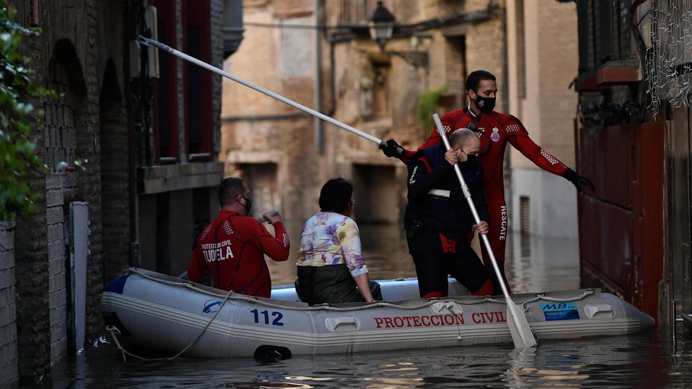 En kvinna evakueras från sitt hem sedan kraftiga skyfall orsakat översvämningar i Tudela nära floden Ebro i norra Spanien i december förra året.