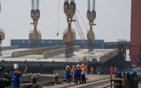Den stora brokonstruktionen lyfts till pontonerna i hamnen i den kinesiska staden Zhongshan för att sedan avgå mot Stockholm.