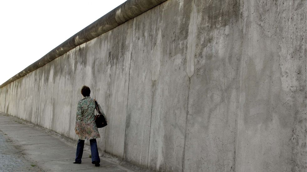 Pappan meddelar med en post-it på kylen att han åkt till hemlandet efter Berlinmurens fall.  Arkivbild.  En bit av bevarad Berlinmur.