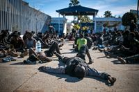 Migranter tar igen sig vid ett migrationscenter i Melilla efter att ha tagit sig över det säkerhetsstaket som skiljer den spanska staden från Marocko.