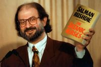 Salman Rushdie håller upp ett exemplar av "Satansverserna" på en presskonferens 1992.