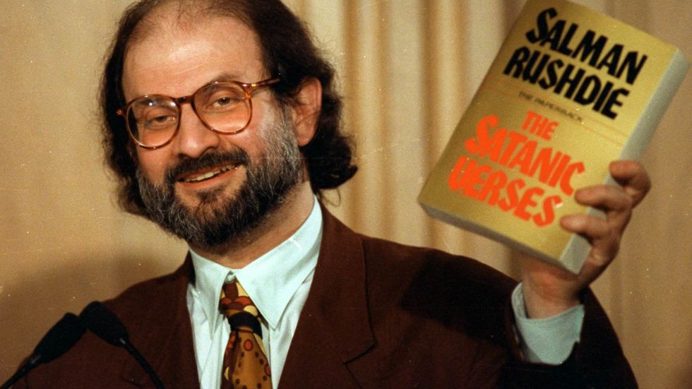 Salman Rushdie håller upp ett exemplar av "Satansverserna" på en presskonferens 1992.