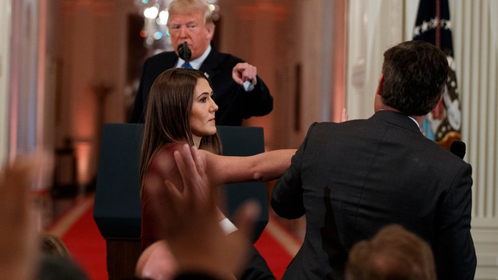  President Donald Trump looks on as a White House aide takes away a microphone from CNN journalist Jim Acosta during a news conference in the East Room of the White House, Wednesday, Nov. 7, 2018, in Washington 