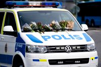 Blommor på en polisbil i Biskopsgården i Göteborg efter mordet den 30 juni. Arkivbild.