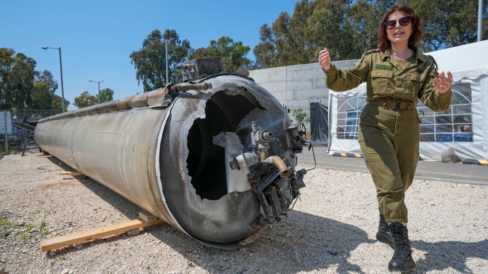 Masha Michelson, biträdande internationell presschef vid IDF, visar upp en av de iranska robotar som sköts ned i södra Israel.