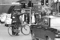 En polisman hjälper en äldre man till rätta i korsningen Sveavägen-Kungsgatan dagen H den 3 september 1967.