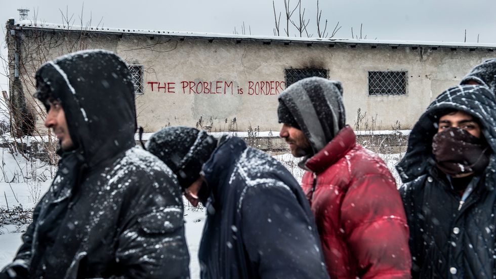 Flyktingar i Serbiens huvudstad Belgrad köar för att få ett mål mat från en frivilligorganisation.