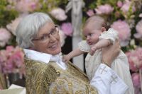 Ärkebiskop Antje Jackelén och prinsessan Adrienne under dopceremonin. Kanske kan lillsessan i framtiden beteckna sig som en skicklig ukulelespelare.