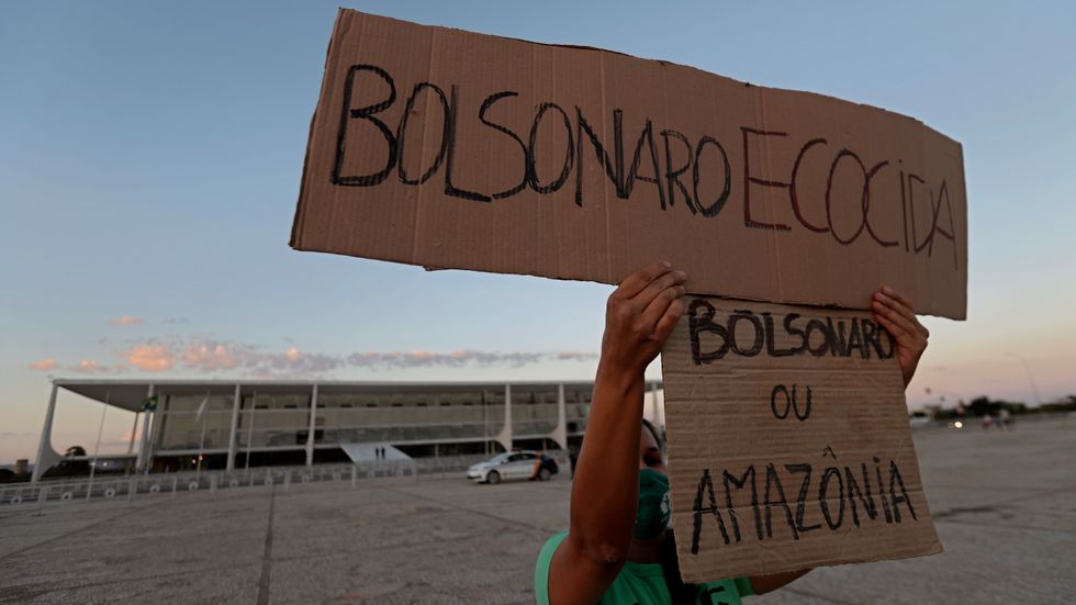 "Bolsonaro eller Amazonas", står det på ett av plakaten vid en protest mot den brasilianske presidentens miljöpolitik i Brasilia 2020.