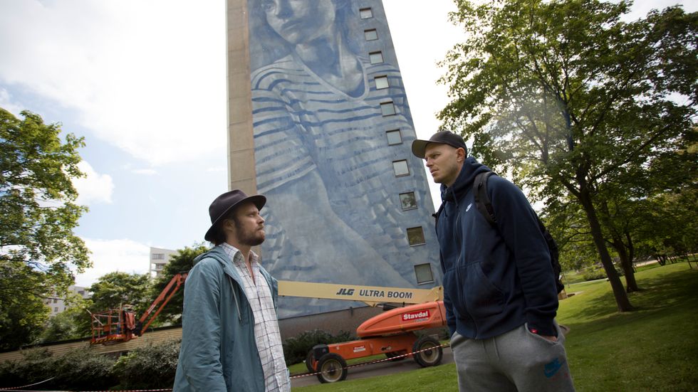 Tor Hedendahl och Daniel Wakeham framför ett av de två trettonvåningshus på Mandolingatan i Frölunda som målades under Artscape 2016. I år kommer gatukonstfestivalen till Ljusdal. Arkivbild.