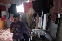 Elvaåriga Zeinaf Jabar från Irak hjälper sin mamma i köket i det övergivna hus där de bor i Bosnien-Hercegovina.