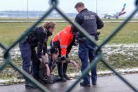 Polis försöker avlägsna en klimataktivist från ”Letzte Generation” vid Berlins flygplats. Arkivbild. 