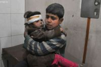 Två syriska barn håller om varandra. De har blivit skadade under flygbomningar och får vård i Ghouta.